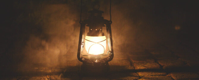 Blog | Schlaf Titelbild Wachsen im Wechsel Martina Pietsch, Leuchtende Laterne steht auf Pflastersteinen und erhellt die Dunkelheit