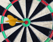 Blog | Perfektionismus | Wachsen im Wechsel Martina Pietsch, Ausschnitt einer Dartscheibe, gelber Pfeil steckt genau in der Mitte